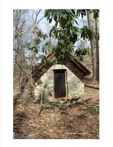 a small stone building in the woods