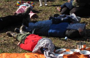 children lying on the ground with bandanas covering their faces
