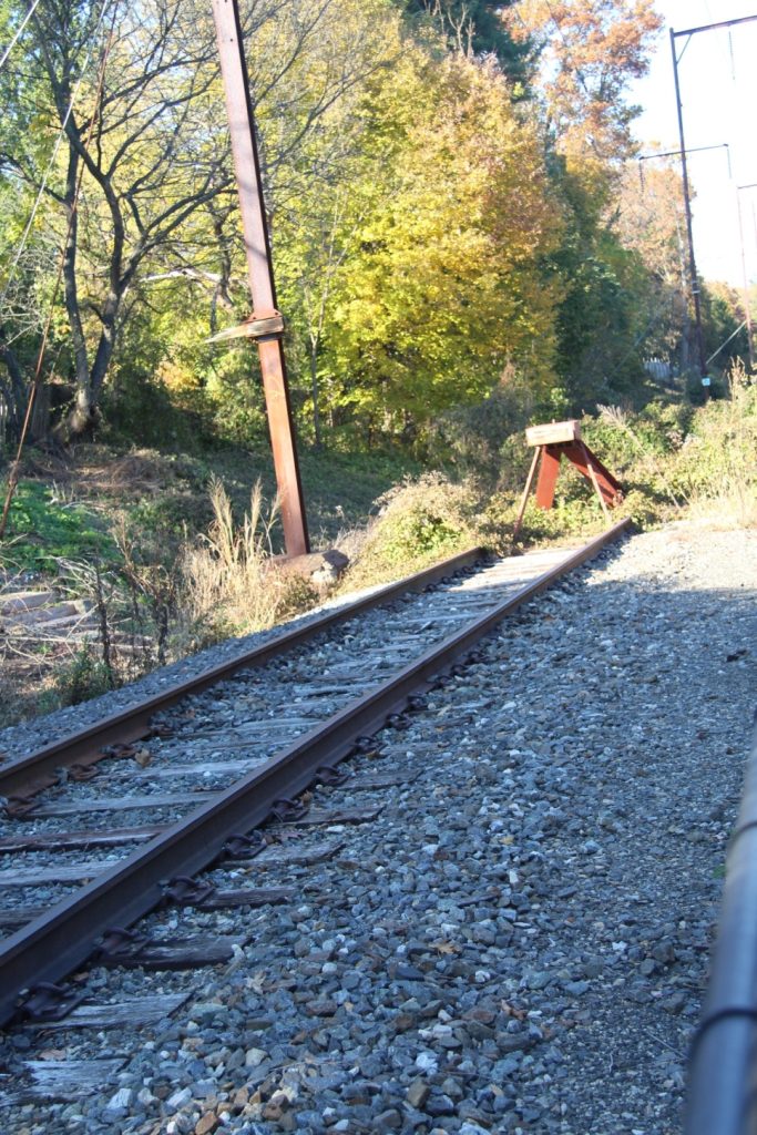 a railroad bed with trees in the background